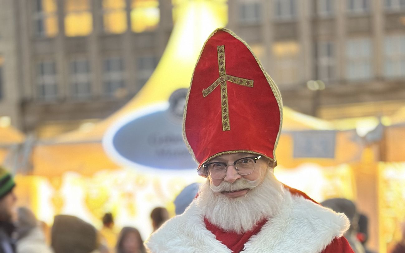 Der Nikolaus mit roter Mitra und goldenem Kreuz, lächelnd beim Weißerzauber